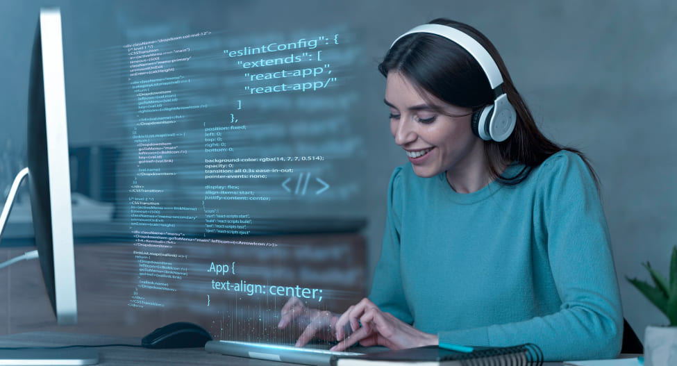 Young woman programer listening to music while working with laptop